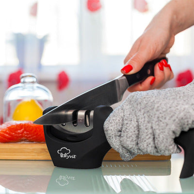 Kitchen knife being sharpened with a 3-stage manual knife sharpener