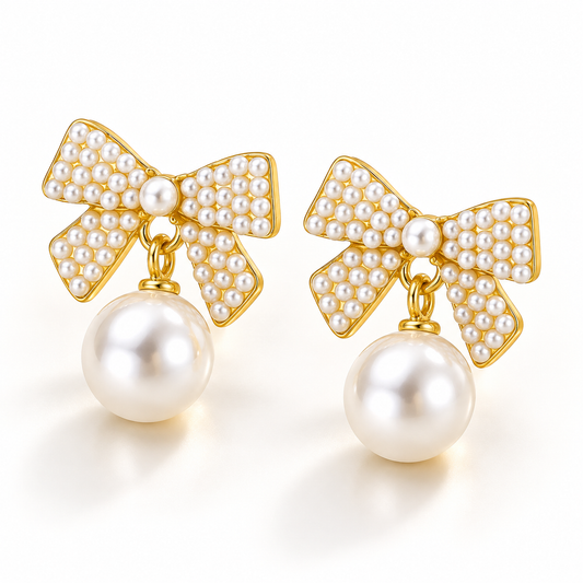 Pair of pearl bow drop earrings with gold-tone detailing on an elegant ivory background.