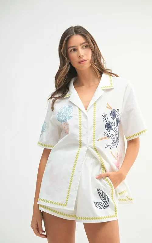 Front view of a model wearing the MABLE embroidered button-down shirt and shorts set