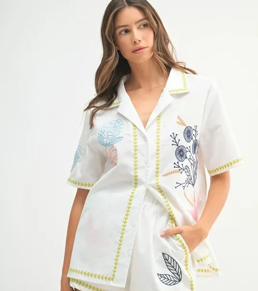 Front view of a model wearing the MABLE embroidered button-down shirt and shorts set