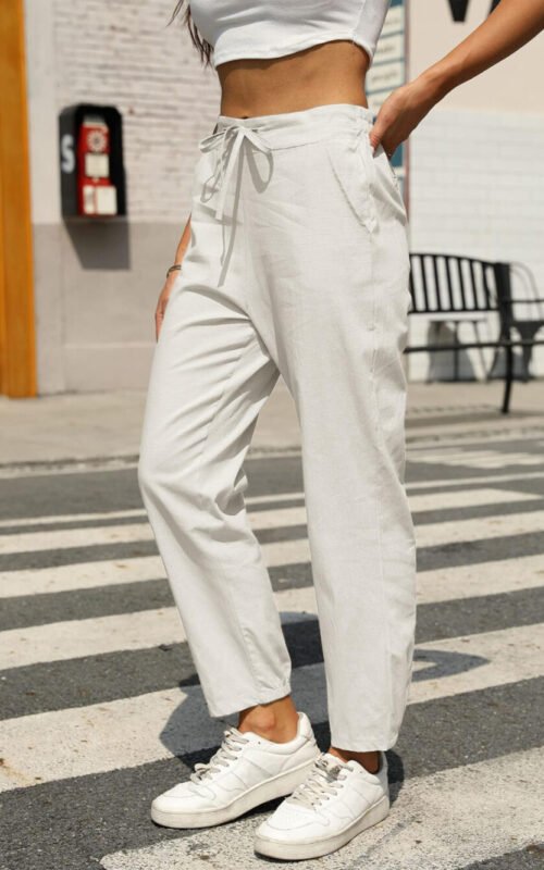 A full-length front view of a woman wearing the Gufumart white linen pants, showcasing their relaxed fit.