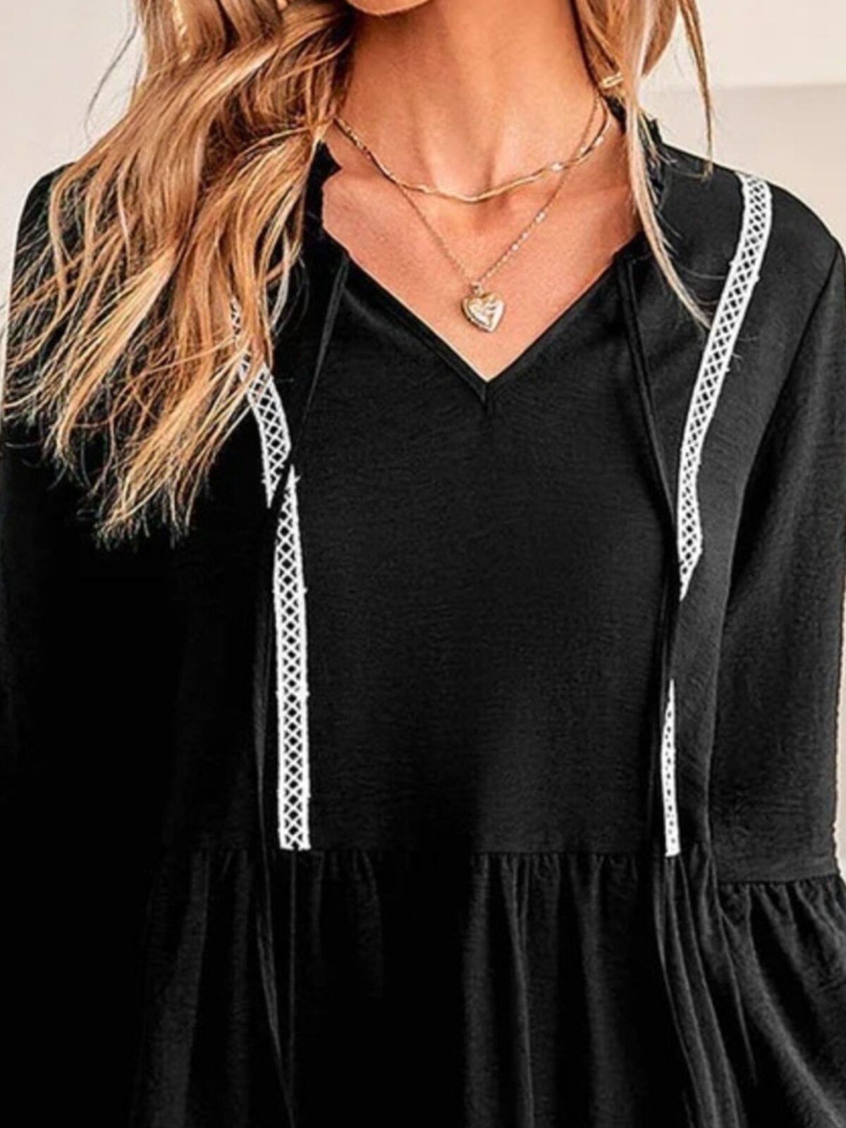 Close up of the contrast stitching and frill detail on the tie neck dress