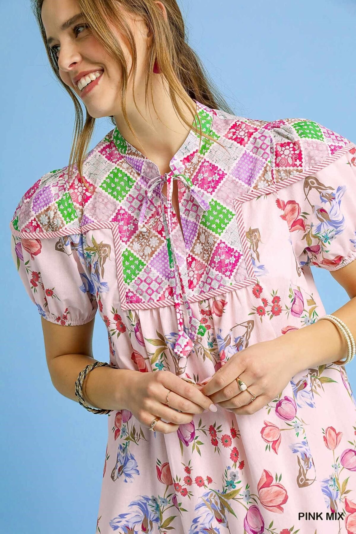 Close-up detail of the puff sleeve and tiered ruffle on a floral print mini dress
